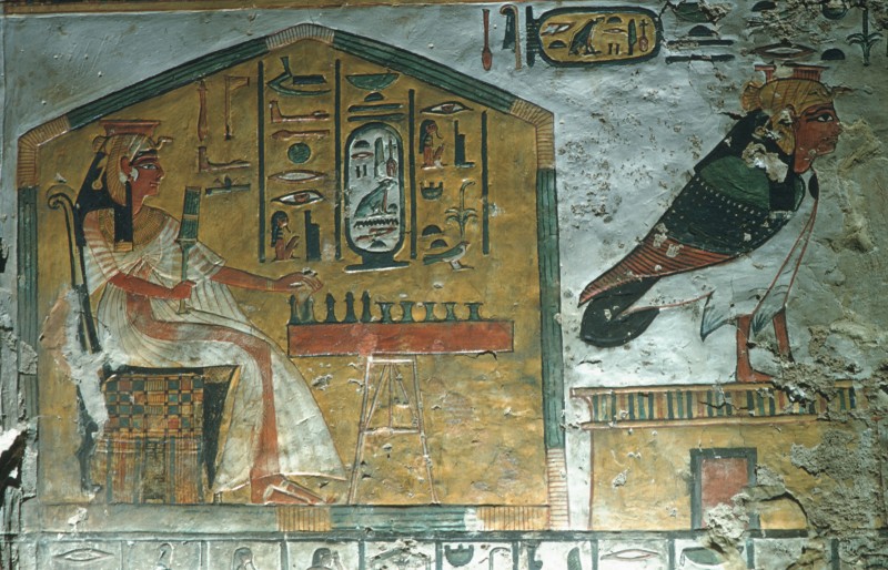 Die Königin unter einer Mattenlaube beim Brettspiel, davor die vogelgestaltige Seele (Ba) auf dem Grabeingang